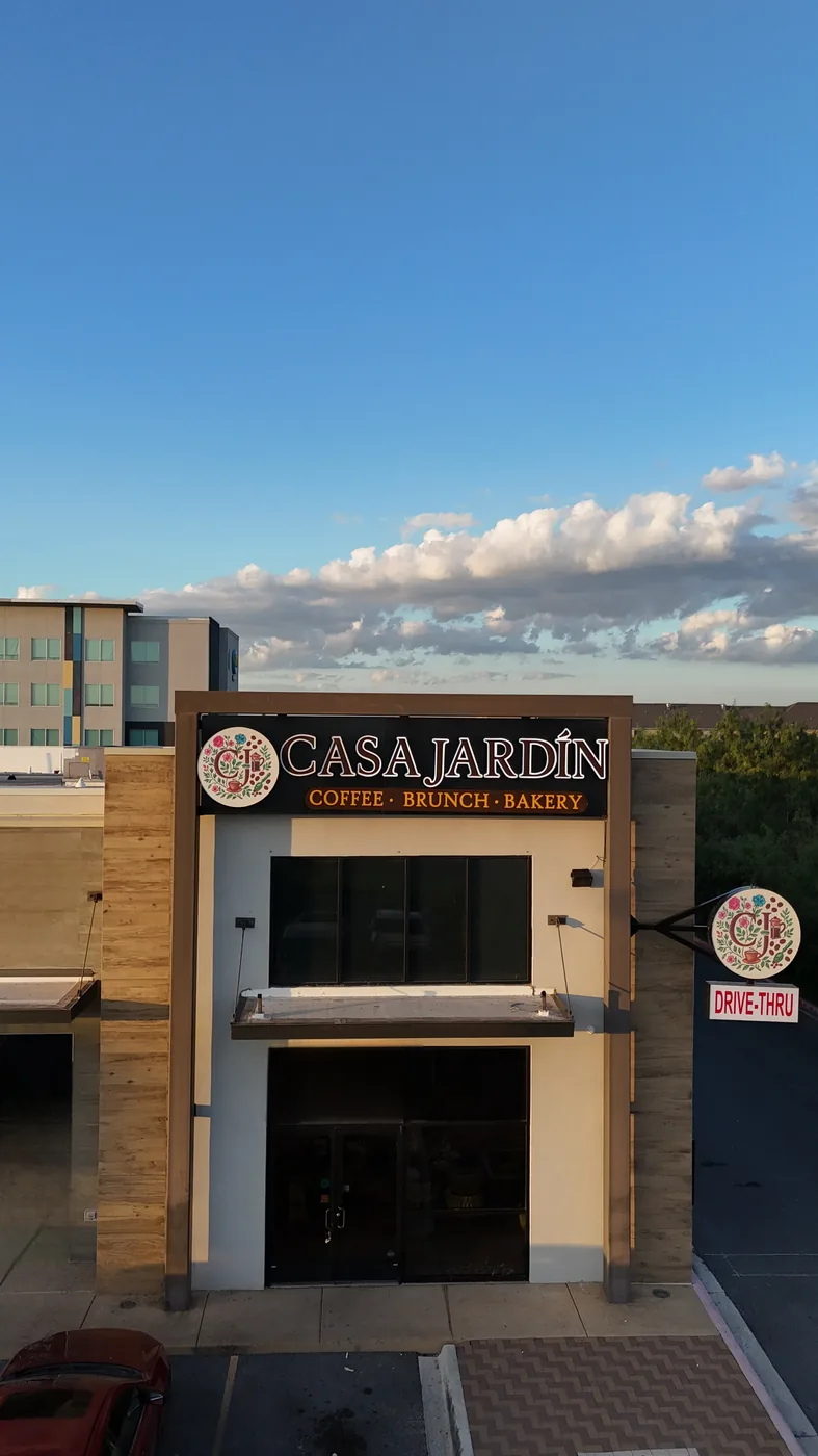 Casa Jardín’s actual storefront and sign beneath a bright blue daytime sky